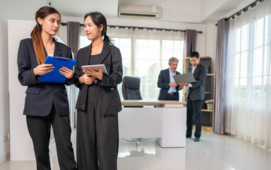 Business team collaborating during office meeting while discussing ideas with laptop and documents,...
