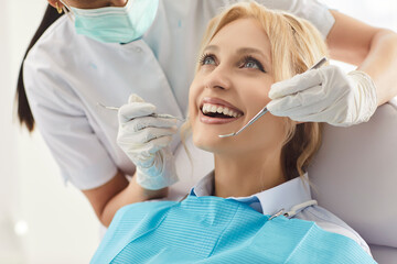 Doctor dentist assists woman patient during clinic visit, checking oral care with dental dentistry...