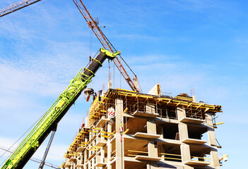 Tower crane on apartment Construction. Block House building construction. Apartments construction. Housing renovation, real estate. Crane on formwork in Built environment. Cranes on pouring concrete.