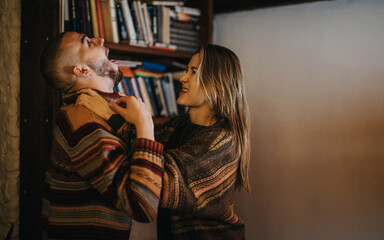 Two individuals engage in a humorous and dynamic interaction while standing in a cozy and stylish...