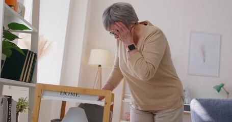 Senior aged mature grey haired woman faints, suffering with sudden headache, single retired female, old lady feels pain attack, looks helpless, worried woman deep troubled with health, stressed - Powered by Adobe