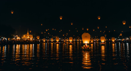 Wooden dock extending into calm lake with reflections at night