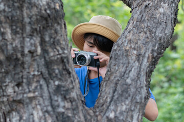 Young asian man tourist taking photo with camera in the forest.