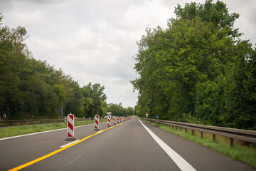 Traffic barriers and lane markings on rural highway during road construction in summer