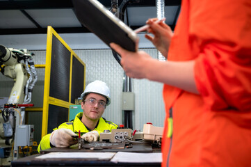 Male robotic engineer working on artificial intelligent robot arm 