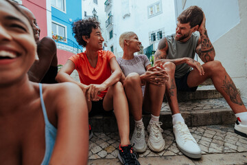 Obraz premium Group of diverse athletes relaxing together on city steps after workout