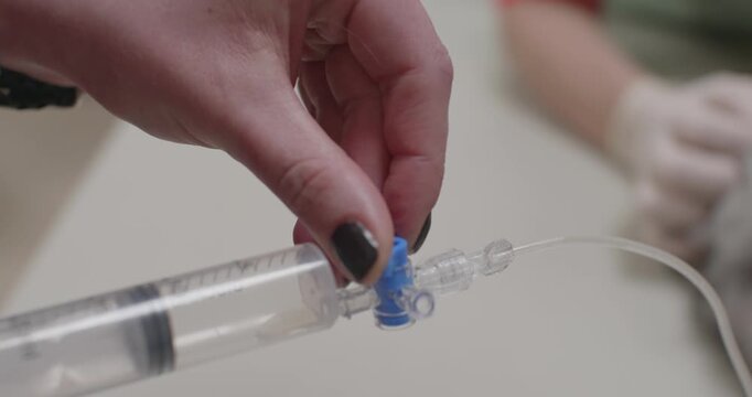 Veterinarian carefully manipulates a syringe with a three-way stopcock to extract accumulated fluid from a cat's abdominal cavity, providing relief and aiding in diagnosis.