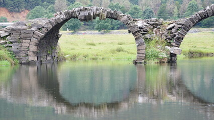 One old traditional Chinese village view with the old arched stone bridge in the Southern...