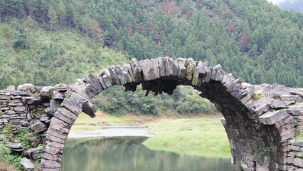 One old traditional Chinese village view with the old arched stone bridge in the Southern countryside of the China