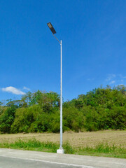 Lamppost on the side of the road. View of a lamppost on a road outside the city against the...