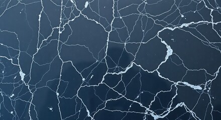 Aerial view of cracked ice formation on a dark body of water in winter season