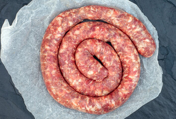 traditional south African boerewors in a round coil on black surface