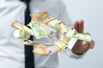 Stock photo of a businessman's hand with floating euro banknotes. Ideal for finance, wealth,...
