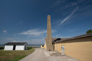 Obraz premium Chimney against blue sky, woman on bench in the background