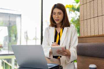 lifestyle of office workers Woman calculating expenses and using laptop. Home office. Work place....