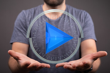 Abstract image of a person presenting a 3D play button.  Ideal for technology, media, and...