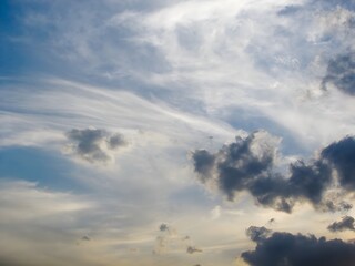 A clear, bright blue sky filled with scattered, fluffy white cumulus clouds on a sunny day.