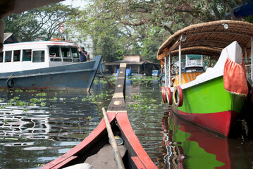 Red and green boats in village canal, India