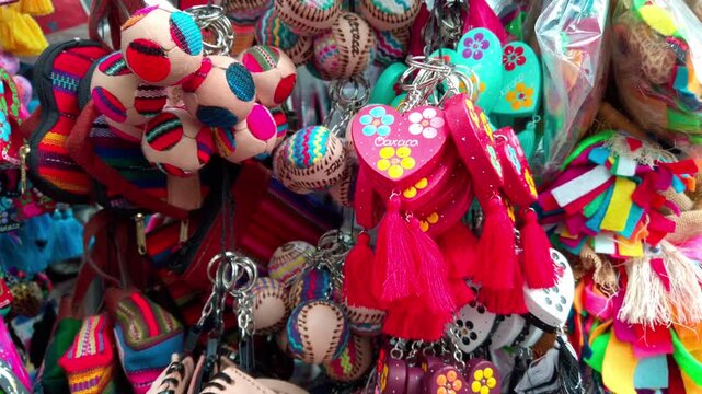 Close-up shot of traditional handmade keychains and souvenirs hanging at a street stall in Oaxaca.