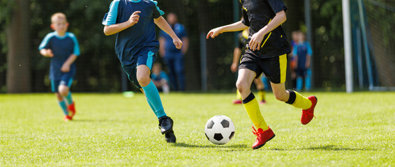 Boys Playing Soccer Match on Green Field. Youth Football Game with Boys in Action in Sports Uniforms