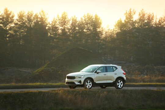 Fototapeta Car on asphalt road surrounded by fall foliage