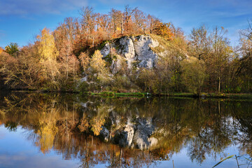Mountain are reflected in the still water of a lake.