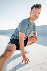 Fitness enthusiast stretches on rooftop during bright sunny day in urban setting
