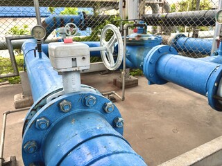 Water pipeline system with blue-coated valves and pressure gauges in an outdoor industrial utility...