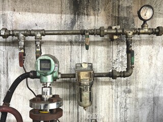 Pressure gauge and sensor setup on an industrial pipeline system, used for monitoring and controlling pressure in manufacturing processes.