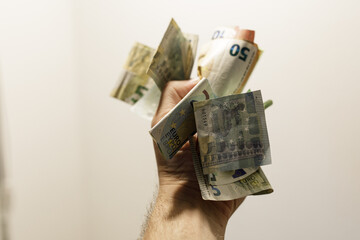 Close-up of a hand holding various euro banknotes.  Financial success concept.