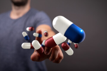 High-quality stock photo of a man reaching for multiple floating pills. Perfect for healthcare,...