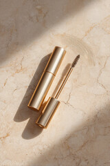 Luxurious gold mascara tube with matching applicator on marble surface, showcasing elegance and sophistication. Perfect for beauty enthusiasts seeking high quality makeup products