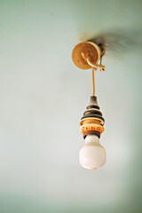 Vintage hanging light bulb over gray background 