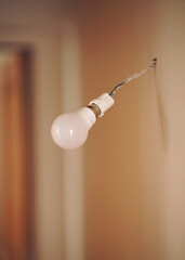 Vintage hanging light bulb over gray background 