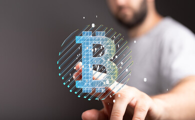 Close-up of a man's hand interacting with a digital Bitcoin hologram. Cryptocurrency, finance,...