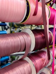 rows bias tape coils display an array colors in crafting workshop, highlighting materials used for...