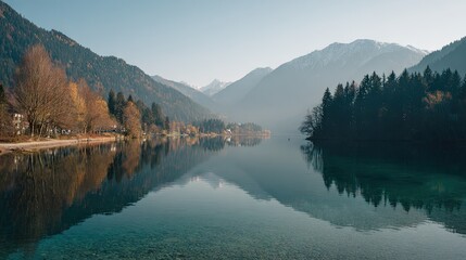 Naklejka premium Calm lake reflecting mountains and trees in a peaceful landscape.