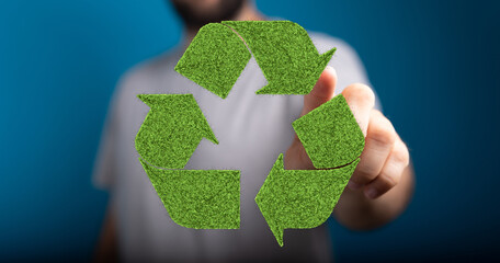 Eco-friendly recycling concept.  Man interacts with a green grass recycle symbol. Sustainable...