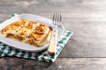 Baked Cannelloni with Cheese and Béchamel Sauce on wooden table. Copy space
