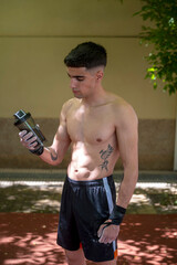 Young athlete holding shaker bottle after calisthenics workout