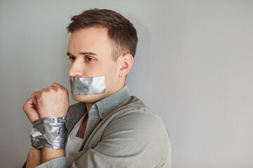 Male victim, young man suffer, mouth and hands taped keeping silent suffering, person harmed,...