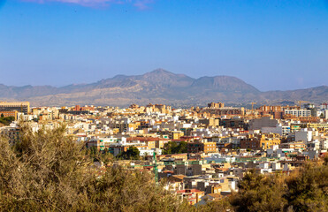 Aerial view of Alicante city with urban architecture, seen under a clear blue sky. The backdrop...