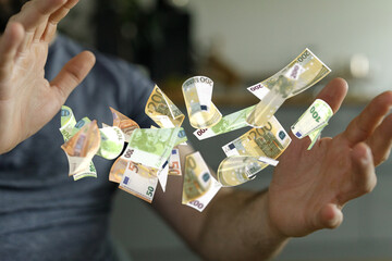 Close-up of hands catching levitating euro banknotes.  Financial success concept.