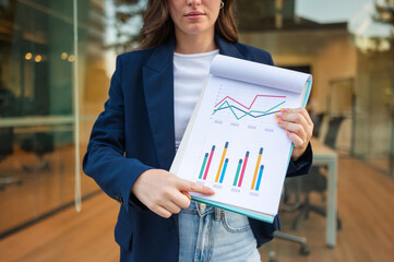 Businesswoman pointing at charts and graphs showing company growth and success