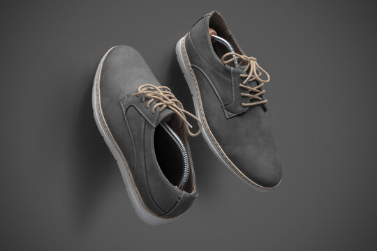 Stylish Gray Suede Casual Shoes with Beige Laces on Gray Background