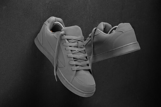 Minimalist grey sneakers on black stone background