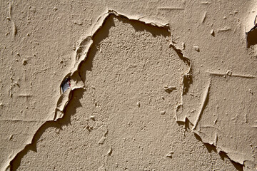 Mur décrépi beige avec décollement de peinture