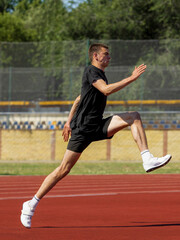 Athlete sprinting while airborne during training on red track. Concept of running phase in pole...