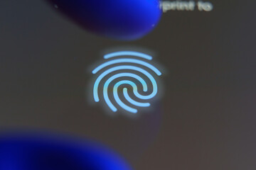 Closeup of a fingerprint icon on a smartphone screen with a finger scanning for biometric...