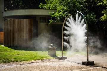 Ein mobiler Sprühbogen versprüht feinen Wassernebel in einem Park in Bratislava, Slowakei
